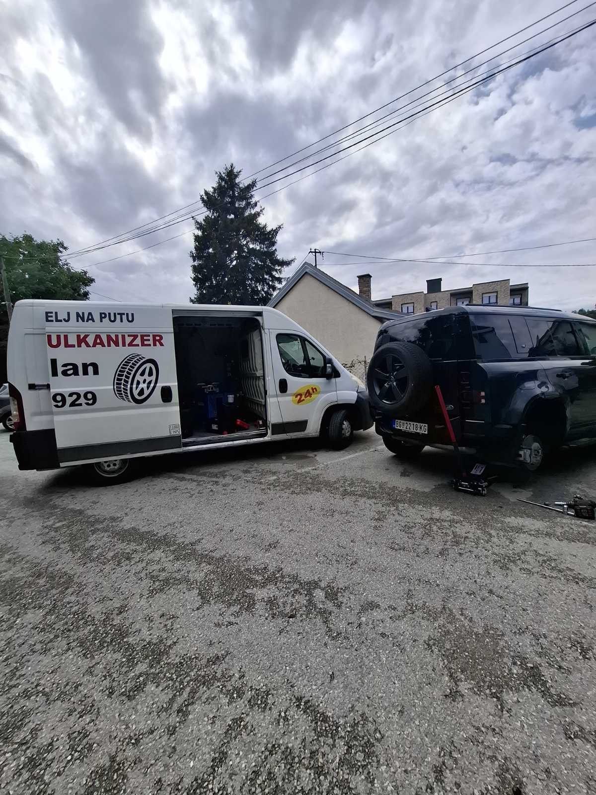 Land Rover Defender na hidrauličnoj dizalici — skidanje točka na parkingu, mobilna vulkanizerska intervencija