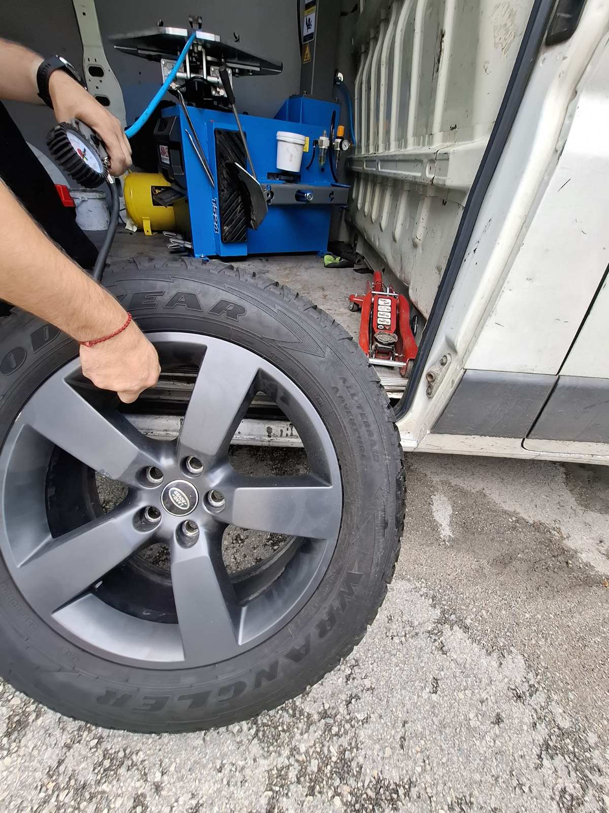 Vulkanizer puni gumu Land Rover vozila pored mobilnog servisnog kombija — intervencija na licu mesta